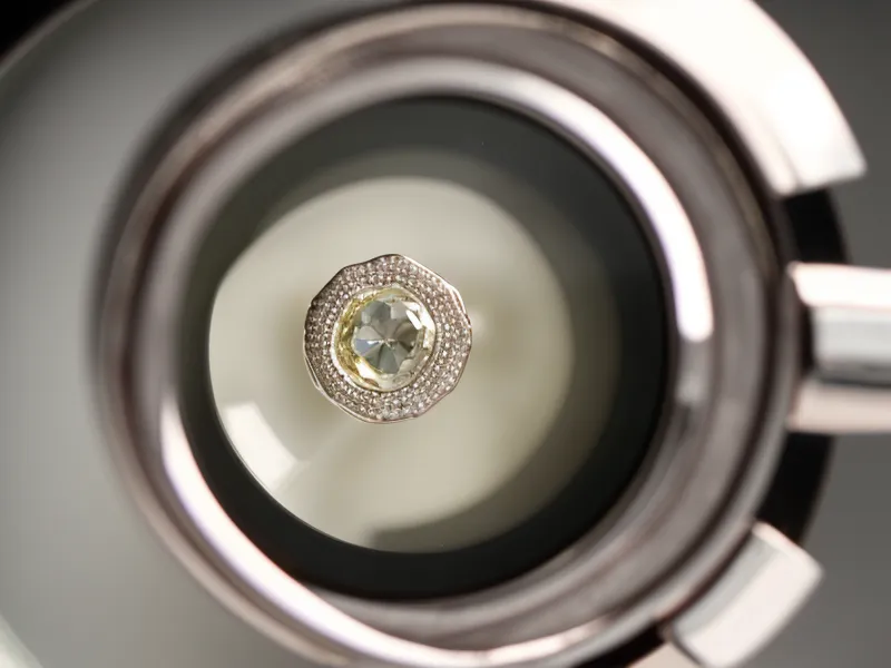 Jeweler's loupe beside a GIA diamond grading certificate, used to verify engagement ring quality claims